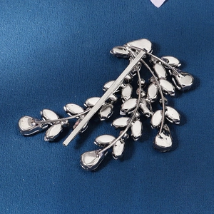 Elegant bridal hair clip with silver leaves and marquise rhinestones on blue fabric