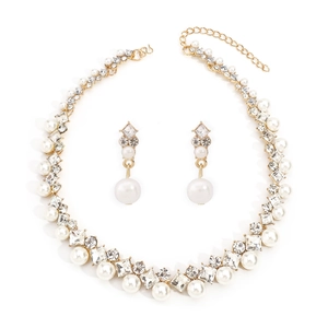 Gros plan sur l'ensemble collier doré orné de perles d'imitation et de strass brillants