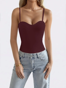 Detail view of burgundy slim fit strapless bodysuit with low neckline and denim pairing