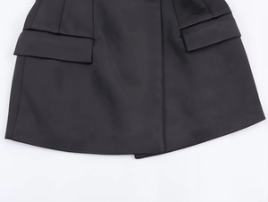 Detailed macro view of black herringbone fabric texture with functional side flap pockets