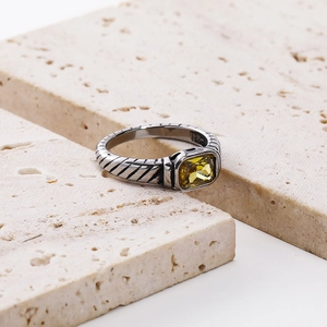 Macro shot of silver vintage ring with a radiant yellow rectangular crystal inlay