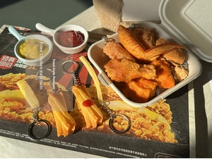 Macro shot of realistic PVC fried chicken and french fries keychain with a metal ring