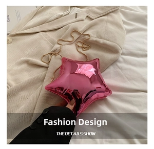 Detail of rose pink star-shaped acrylic mini bag with fine gold chain on beige fabric