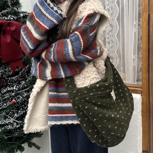 Detail of green fleece crossbody bag with white dots and textured plush fabric finish