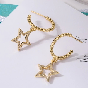 Gold-plated star drop earrings with sparkling zircon crystals on white card background