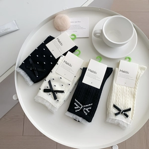 Chaussettes style japonais avec nœuds, pois et dentelle sur plateau blanc