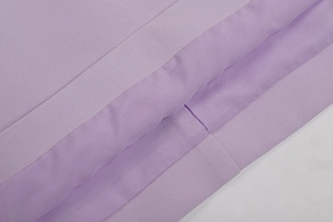 Detailed close-up of purple knit fabric texture and high-quality seamless stitching
