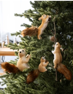 Realistic furry squirrel ornaments in four poses hanging on a Christmas tree branch