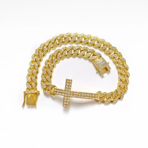 Iced out gold Cuban link bracelet with sparkling cross pendant and box clasp closure