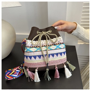 Close-up of ethnic bucket bag featuring colorful woven patterns and decorative tassels