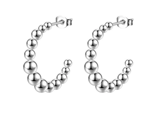 Detailed view of silver beaded C-shaped hoop earrings with polished steel spheres
