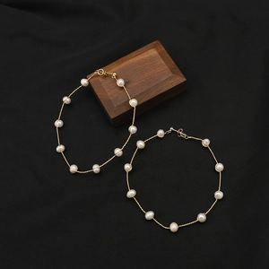 Elegant 18K gold-plated large hoop earrings with white pearls on a minimalist wire frame