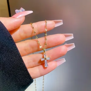 Close-up of gold-plated cross necklace pendant featuring inlaid rectangular zirconia