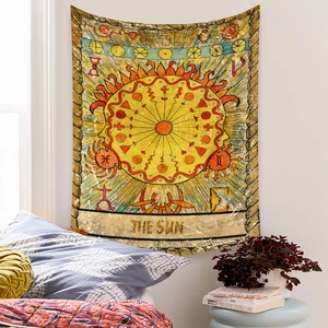 Detail of vintage tarot tapestry The Sun hanging on a bedroom wall with cozy home decor