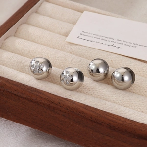 Polished silver sphere stud earrings and heart-set crystal ball studs on display