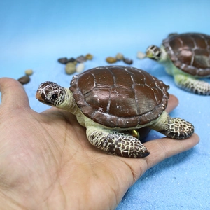 Realistic resin sea turtle figurine held in palm for miniature garden aquarium decor