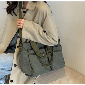 Olive green corduroy tote bag detail showing multi-pocket design and retro workwear style