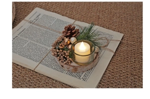 Macro view of Christmas glass candle holder with LED candle on birch wood base