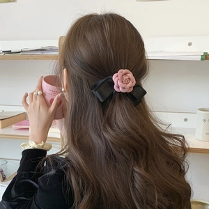 Camellia flower bow hair clip on long wavy hair for elegant half-tied styling