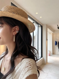 Detail of silver teardrop earrings with white shell inlay worn by a female model