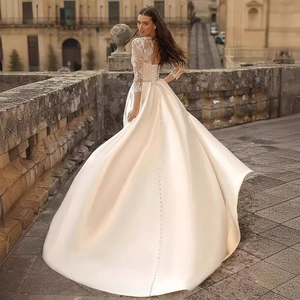 Elegant ivory long sleeve bridal gown with lace embroidery and long satin train
