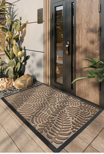 Detail of non-slip rubber door mat with brown leaf pattern on textured polypropylene