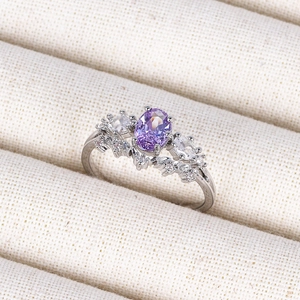 Macro detail of silver ring featuring oval purple gemstone and sparkling side stones