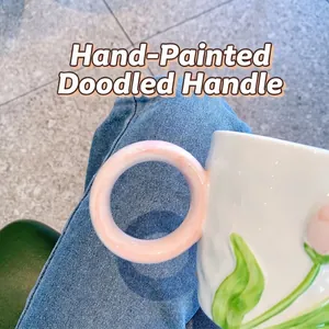 Artistic ceramic tulip mug featuring cream glaze and a unique pink round doodle handle