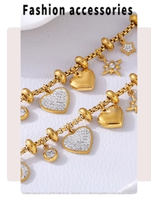 Macro detail of gold plated bracelet featuring star and heart charms with zircon stones