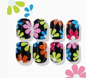 Detailed view of short round black press-on nails with colorful daisy floral patterns