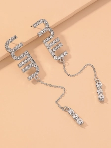 Close-up of silver-tone tassel earrings featuring crystal M letters and hanging chains