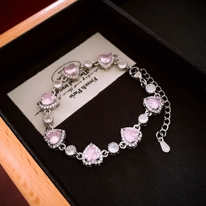 Close-up of pink zircon heart pendant on S925 sterling silver bracelet in a jewelry box