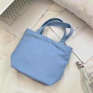 Light blue canvas tote bag on a desk with a laptop and sketchbook for daily use