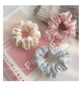 Dettaglio di elastici per capelli in tulle a fiori color crema rosa e blu