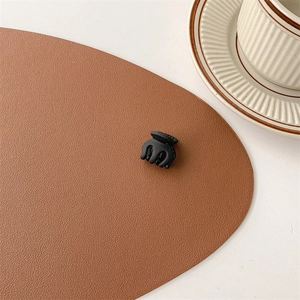 Detailed close-up of a matte black mini hair claw clip on a stylish desk setting