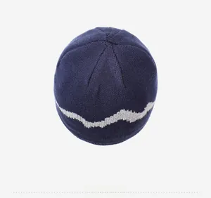 Top view of dark blue knitted beanie featuring grey wavy pattern and fine stitching