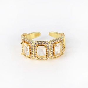 Detail of gold-plated adjustable ring featuring three baguette-cut clear zircon stones