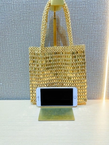 Detail of handmade gold beaded tote bag with a smartphone for size reference