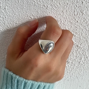 Vintage 925 sterling silver oval embossed ring for women on a textured background