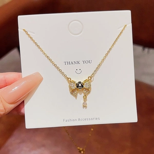 Macro detail of gold bow and camellia pendant necklace with sparkling zircon stones