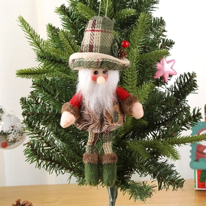 Plush Santa Claus ornament with red coat and green knitted hat on a Christmas tree