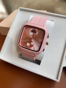 Detailed view of square rose gold watch with pink silicone strap in a white gift box