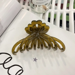 Detail of translucent olive green flower hair claw clip on white lifestyle background