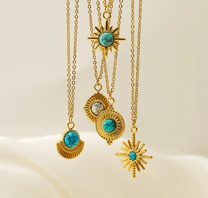 Detailed view of 18K gold plated celestial pendants with turquoise and starburst motifs