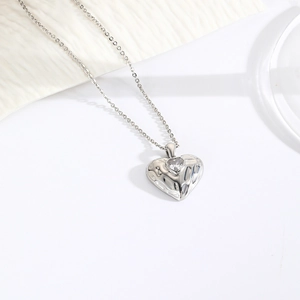Detail of silver heart necklace with hammered texture and a sparkling zircon stone