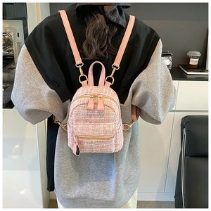 Pink tweed mini backpack detail showing the golden metal zipper and woven texture