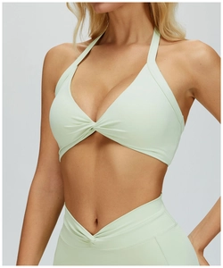 Detail of mint green halter yoga bra with front twist knot and high waist V-cut leggings