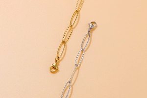 Detail view of gold and silver stainless steel chain bracelets with lobster clasps