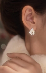 Close-up of a model wearing a sparkling Christmas tree stud earring with cubic zirconia