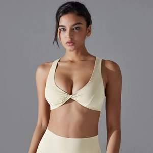 Detail of light yellow sports bra featuring a twist-knot front and high-elastic yoga fabric